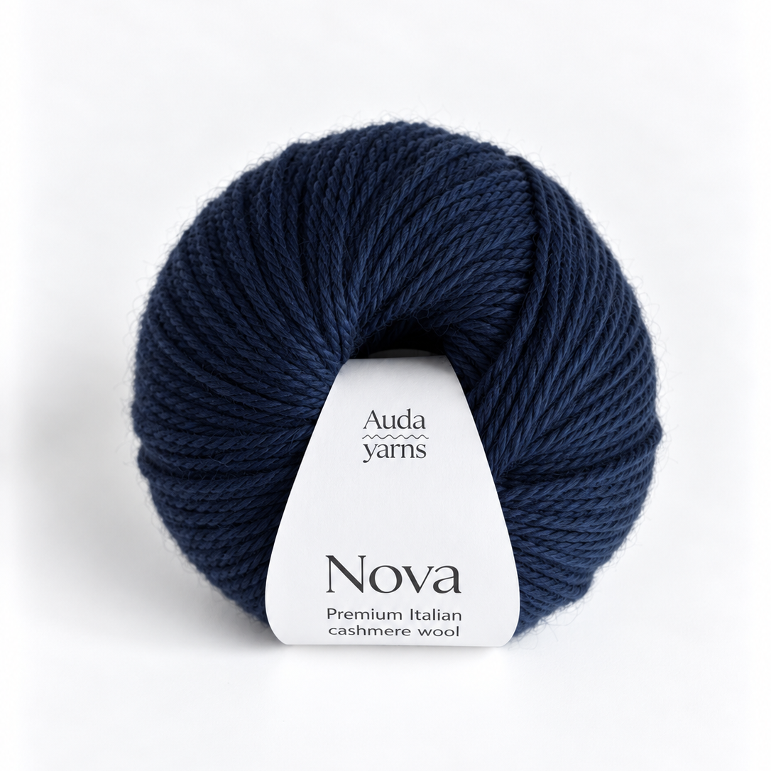 A single skein of Auda Yarns Nova yarn in a deep navy blue color, featuring a white paper label, set against a clean white background.