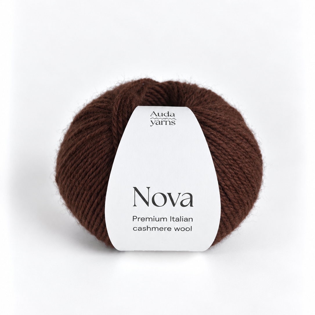 A ball of dark brown yarn with a white paper label that reads 'Auda yarns Nova Premium Italian cashmere wool' on a clean white background.