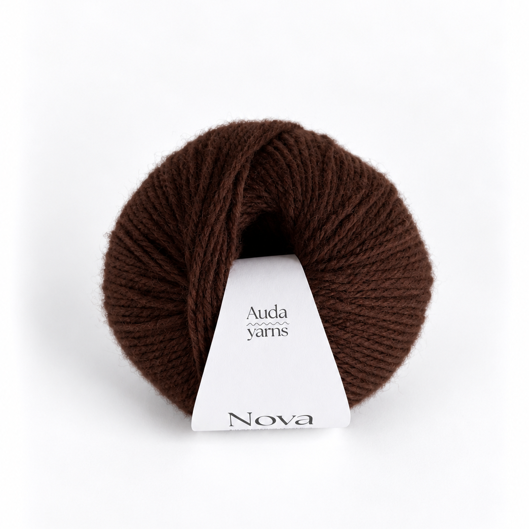 A skein of dark brown yarn with a white paper label that reads 'Auda yarns Nova' on a clean white background.