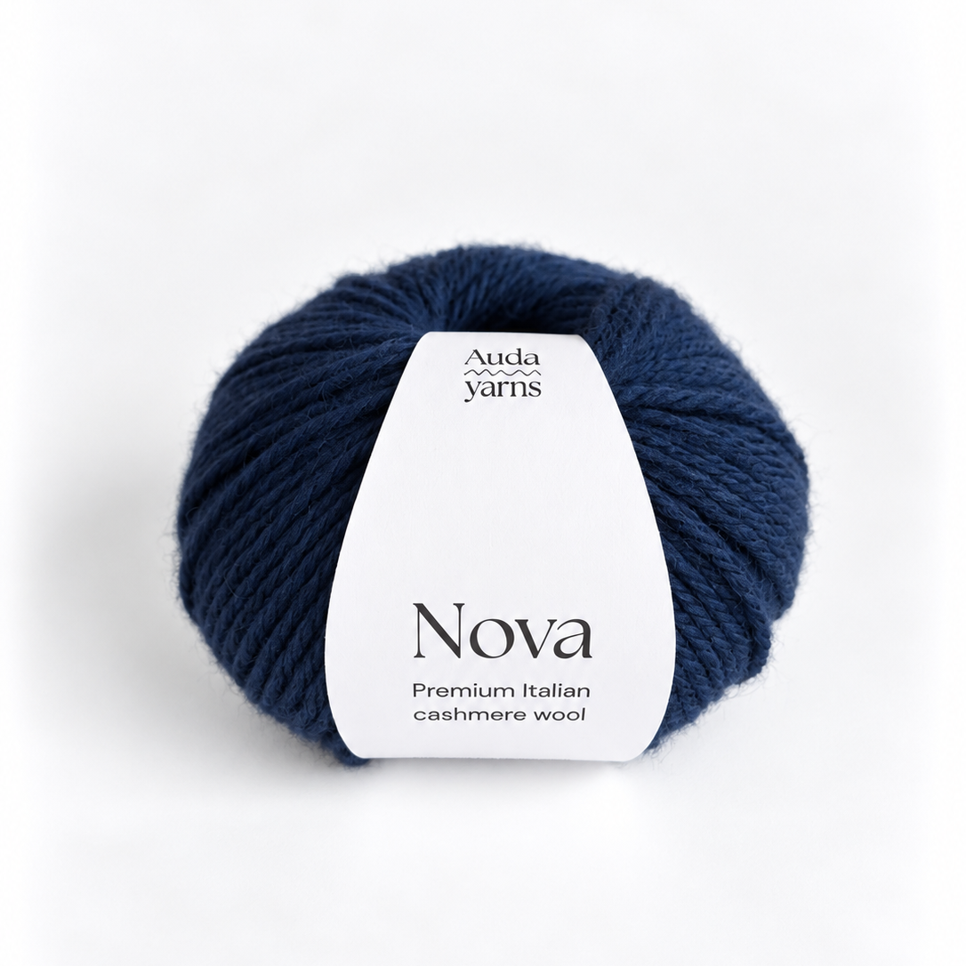A single ball of Auda Yarns Nova yarn in a deep navy blue color, featuring a white paper label wrapped around the center, set against a clean white background.
